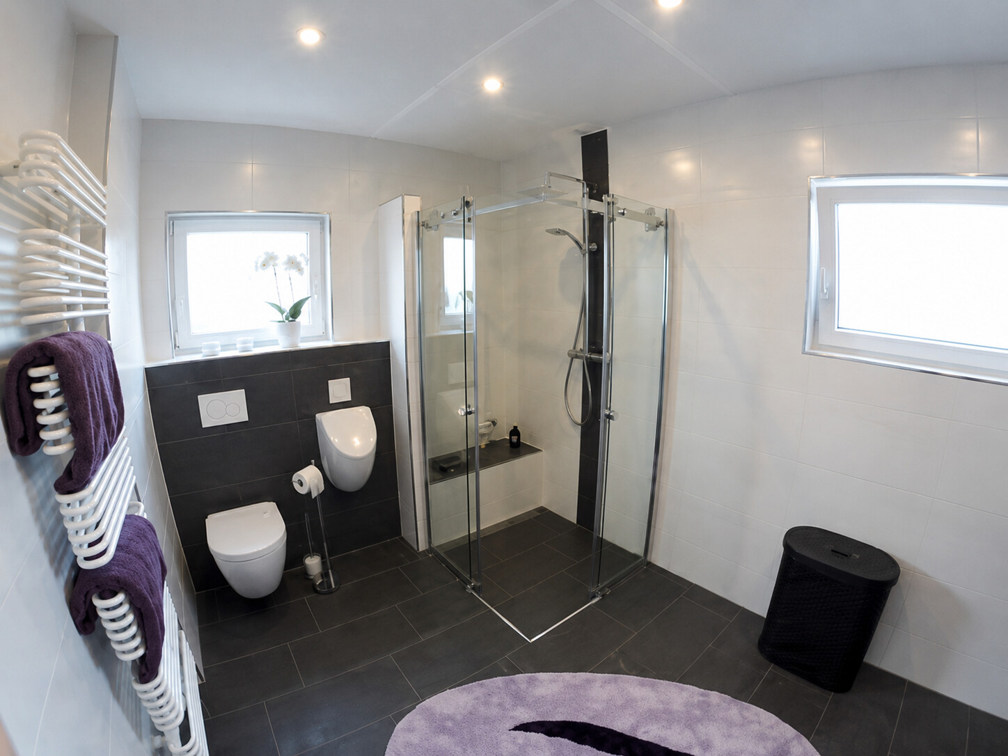 Helles Badezimmer mit großzügiger Glasdusche und Wand-WC